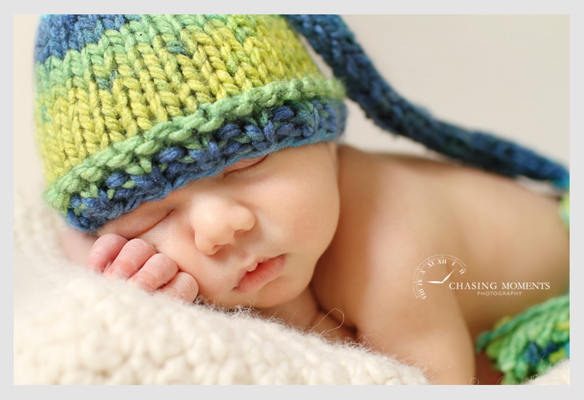 newborn baby boy in a pixie hat asleep