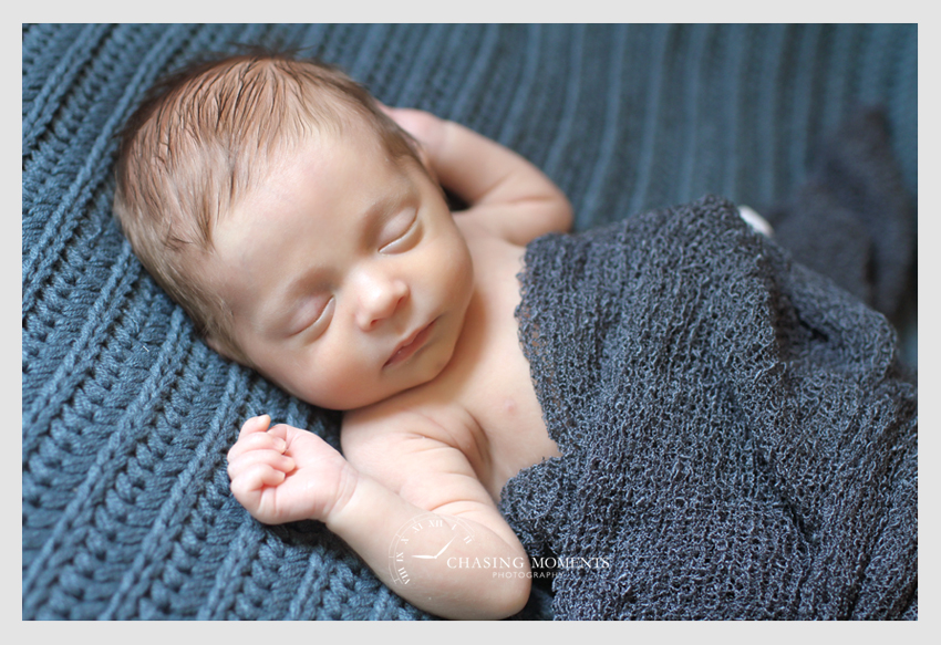newborn baby boy asleep on a blue blanket