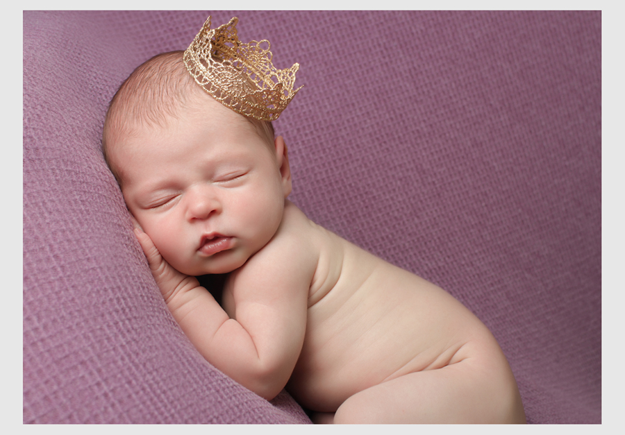 sleeping newborn baby girl wearing crown
