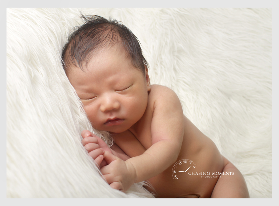 newborn baby asleep on white fur professional newborn photography